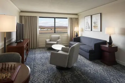 a living room with a couch and chairs in a hotel room at Sheraton Hartford Hotel at Bradley Airport in Windsor Locks