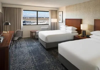 a hotel room with two beds and a desk at Sheraton Hartford Hotel at Bradley Airport in Windsor Locks