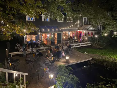 a group of people sitting on a deck at night at The Cornell Inn, Lenox & The Berkshires in Lenox