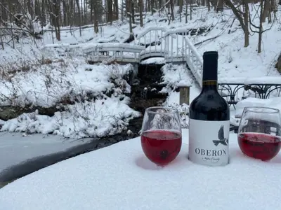 a bottle of wine next to a glass of red wine at The Cornell Inn, Lenox & The Berkshires in Lenox