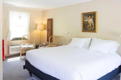 a bedroom with a large white bed and a window at The Little Lion in Great Barrington