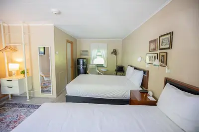 a hotel room with two beds and a bathroom at The Little Lion in Great Barrington