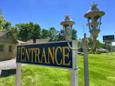 a street light with a sign that reads the entrance at Scottish Inns Milford in Milford
