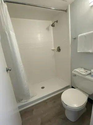 a white bathroom with a shower and a toilet at Motel 6-Windsor Locks, CT - Hartford in Windsor Locks