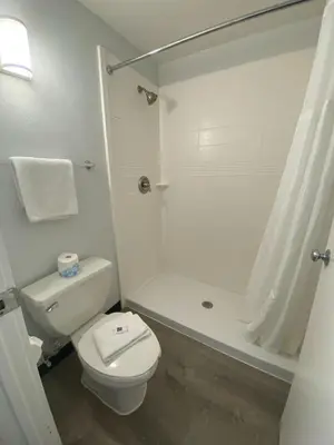 a white bathroom with a toilet and a shower at Motel 6-Windsor Locks, CT - Hartford in Windsor Locks