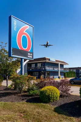 a sign in front of a building with an airplane at Motel 6-Windsor Locks, CT - Hartford in Windsor Locks