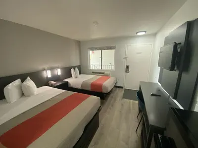 a hotel room with two beds and a flat screen tv at Motel 6-Windsor Locks, CT - Hartford in Windsor Locks