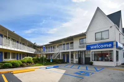 a building with a welcome sign in a parking lot at Motel 6-Southington, CT - Hartford in Southington