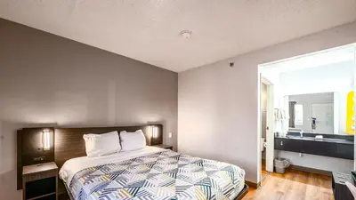 a bedroom with a bed and a large window at Motel 6-Wethersfield, CT - Hartford in Wethersfield