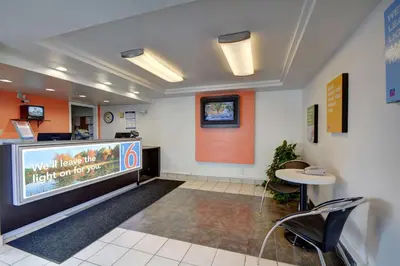 a waiting room with a large tv and a table at Motel 6-Chicopee, MA - Springfield in Chicopee