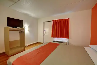 a room with a bed with a television and a window at Motel 6-Chicopee, MA - Springfield in Chicopee