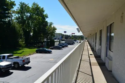 a balcony of a building with cars parked in a parking lot at Motel 6-Chicopee, MA - Springfield in Chicopee
