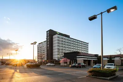 a large building with cars parked in a parking lot at Holiday Inn Newark International Airport in Newark