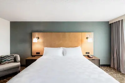 a bedroom with a large bed and a chair at Holiday Inn Newark International Airport in Newark