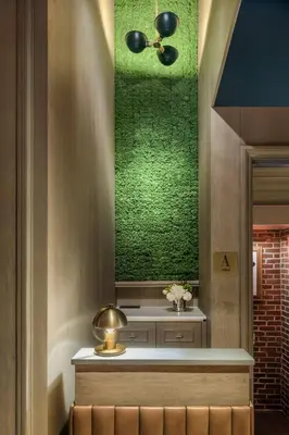 a room with a green wall and a bench with flowers at Merrion Row Hotel and Public House in New York