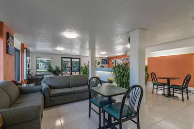 a living room with a couch and a table and chairs at MOTEL 6 - Albany, NY - Airport in Albany