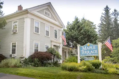 a sign in front of a house with a market mortgage sign at Maple Terrace Motel in Williamstown