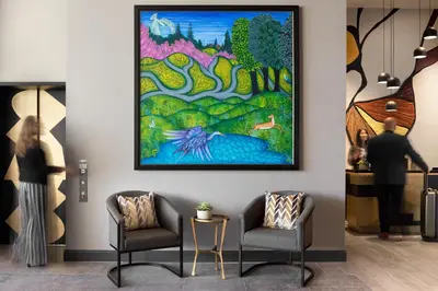 a man standing in a room with a painting on the wall at The MC, Autograph Collection in Montclair