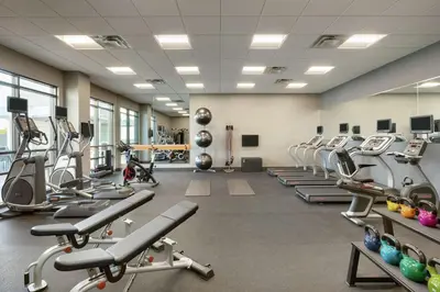 a gym with rows of treadmills and machines at Homewood Suites by Hilton Albany Crossgates Mall in Albany