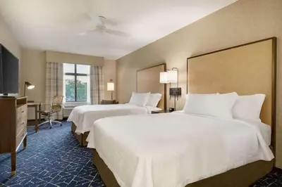 a hotel room with two beds and a flat screen tv at Homewood Suites by Hilton Albany Crossgates Mall in Albany