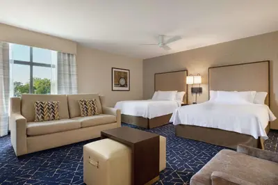 a hotel room with two beds and a couch at Homewood Suites by Hilton Albany Crossgates Mall in Albany