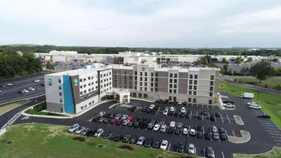 an aerial view of a building with a parking lot at Homewood Suites by Hilton Albany Crossgates Mall in Albany