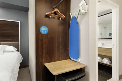 a room with a surfboard on a wall next to a bed at Tru by Hilton Albany Crossgates Mall in Albany