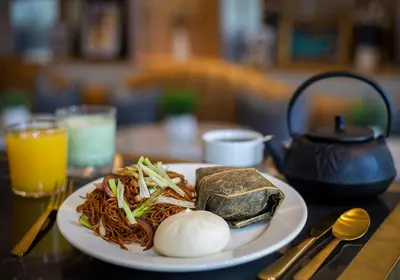 a plate of food with noodles on a table at voco Fiorello - LaGuardia Airport by IHG in Queens