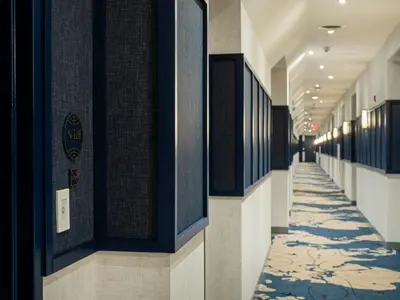 a hallway of a building with black and white tiles at voco Fiorello - LaGuardia Airport by IHG in Queens