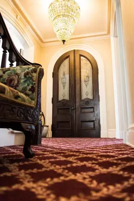 a room with two doors and a couch and a chandelier at The Bevin House B&B in East Hampton