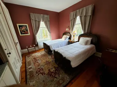 a bedroom with two beds and a rug at The Bevin House B&B in East Hampton