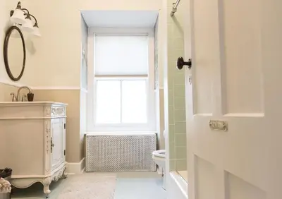 a bathroom with a toilet and a window at The Bevin House B&B in East Hampton