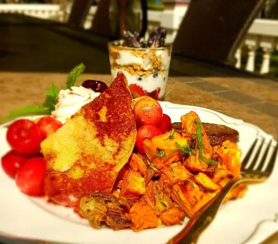 a plate of food with toast and vegetables on a table at The Bevin House B&B in East Hampton
