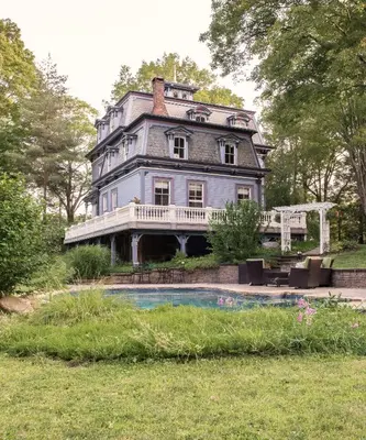 a large house with a pool in front of it at The Bevin House B&B in East Hampton