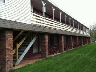 a large brick building with stairs and a grass field at Waterford Inn in Waterford