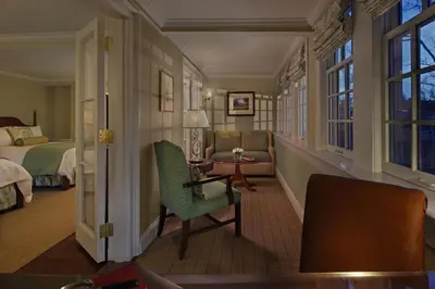 a bedroom with a bed and a chair and a table at Inn on Boltwood in Amherst
