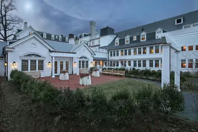 a large white house with tables and chairs in the yard at Inn on Boltwood in Amherst