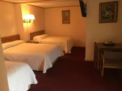 a hotel room with two beds and a table at Motel 88 in Oneonta