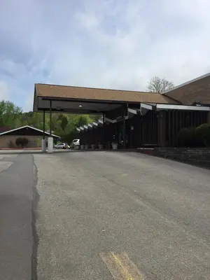 a gas station with a building with a roof at Motel 88 in Oneonta
