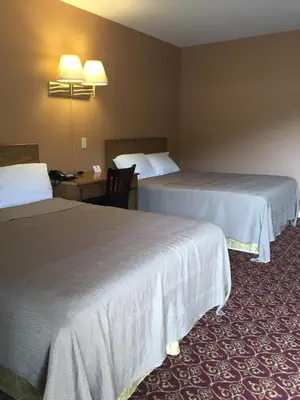 a hotel room with two beds and a desk at Motel 88 in Oneonta