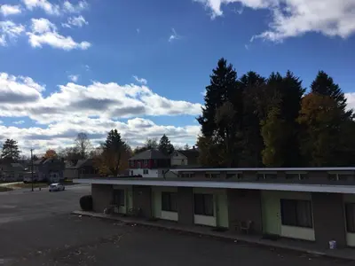 a parking lot in front of a building with a car at Motel 88 in Oneonta