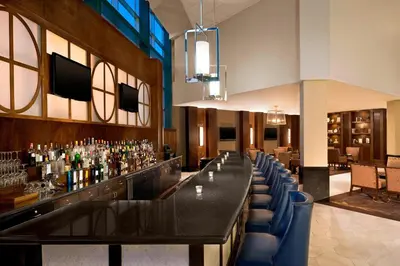 a bar in a restaurant with blue chairs at The Stamford Hotel in Stamford