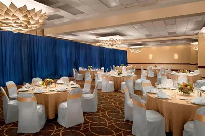 a banquet room with tables and chairs and a blue curtain at The Stamford Hotel in Stamford