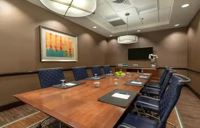 a conference room with a large wooden table and chairs at The Stamford Hotel in Stamford