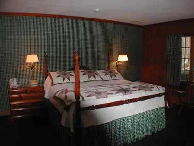 a bedroom with a bed in a room with green walls at The 1896 House Country Inn - Brookside & Pondside in Williamstown