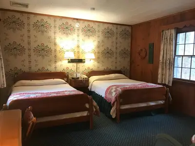 a bedroom with two beds and a window at The 1896 House Country Inn - Brookside & Pondside in Williamstown