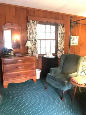 a living room with a chair and a dresser at The 1896 House Country Inn - Brookside & Pondside in Williamstown
