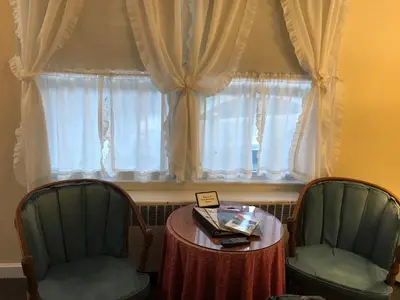 two chairs and a table in front of a window at The 1896 House Country Inn - Brookside & Pondside in Williamstown