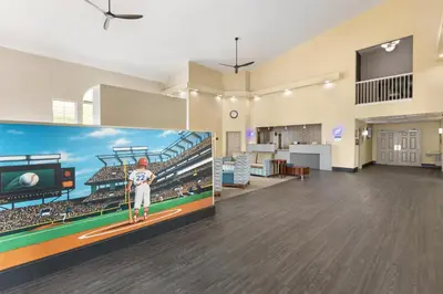 an empty lobby with a large picture of a baseball game at Best Western Cooperstown in Cooperstown