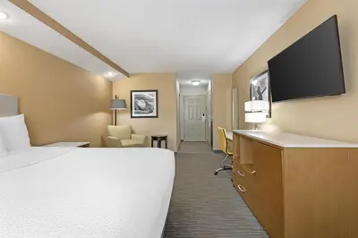 a hotel room with a bed and a flat screen tv at Best Western Cooperstown in Cooperstown